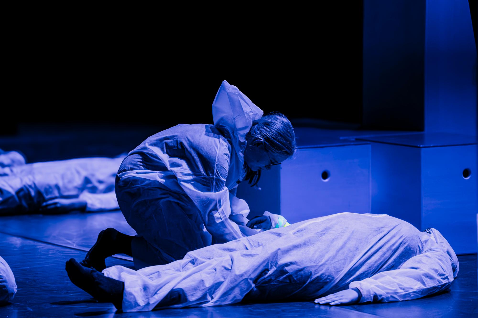 Eine Person beugt sich über eine andere und weckt sie